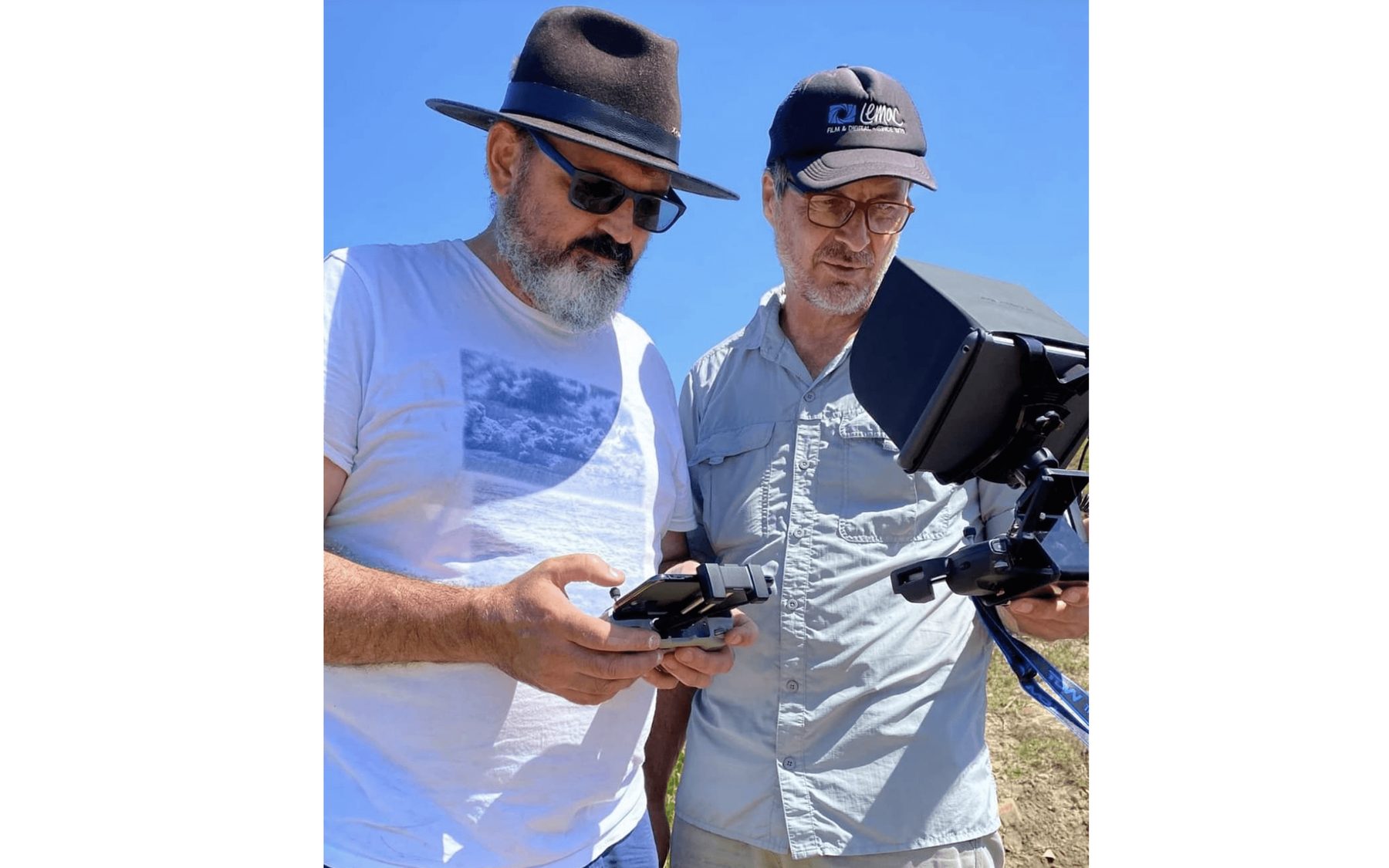 Crew reviewing drone footage on a monitor in the field