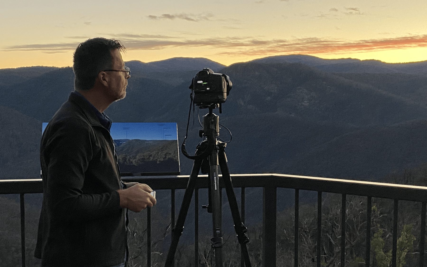 Camera set up on a ridge lookout at sunset