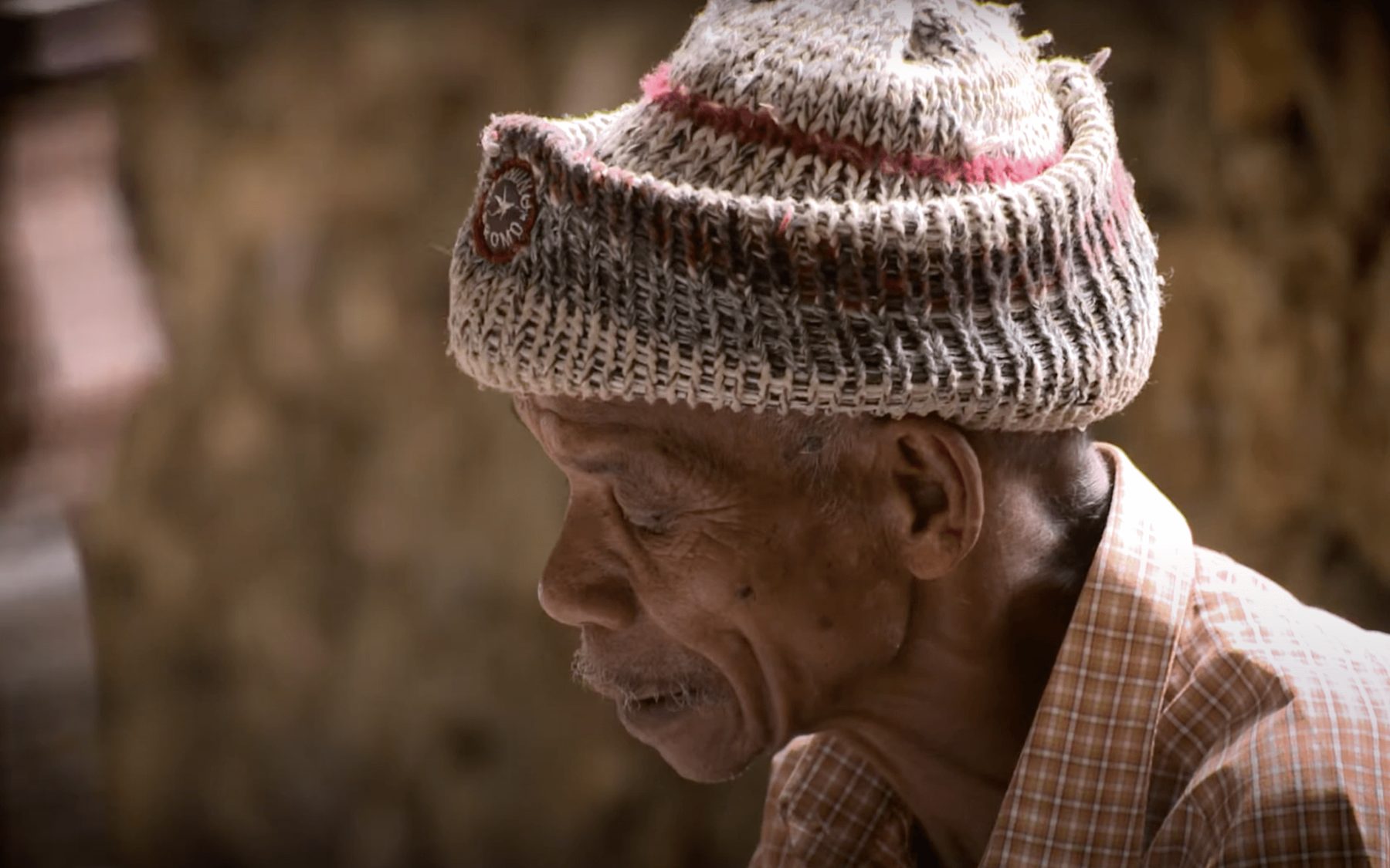Portrait of a local community elder involved in an archaeological research documentary, illustrating community and cultural connection