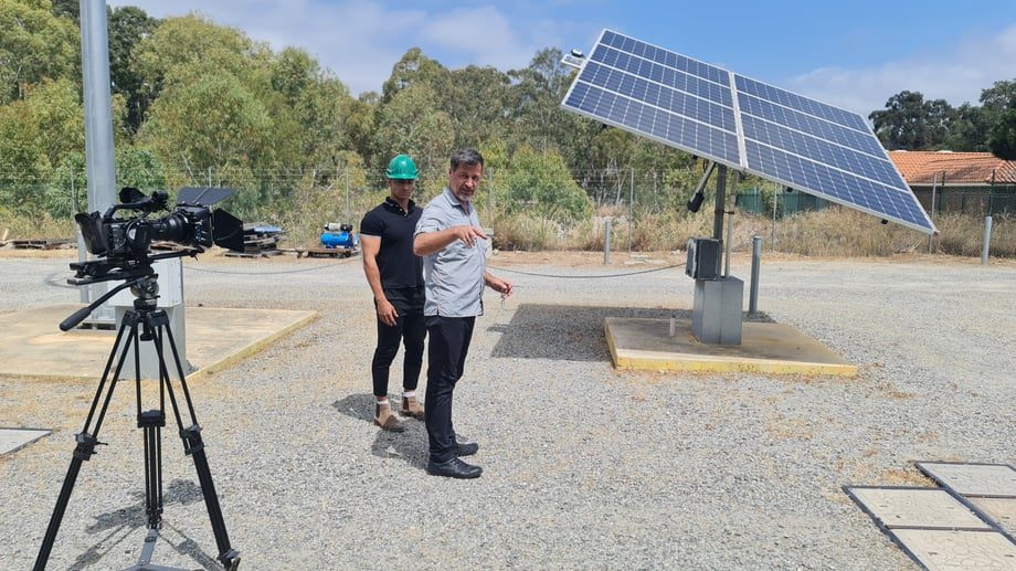 Researcher and crew member at a solar research site, filming video content to engage funding stakeholders