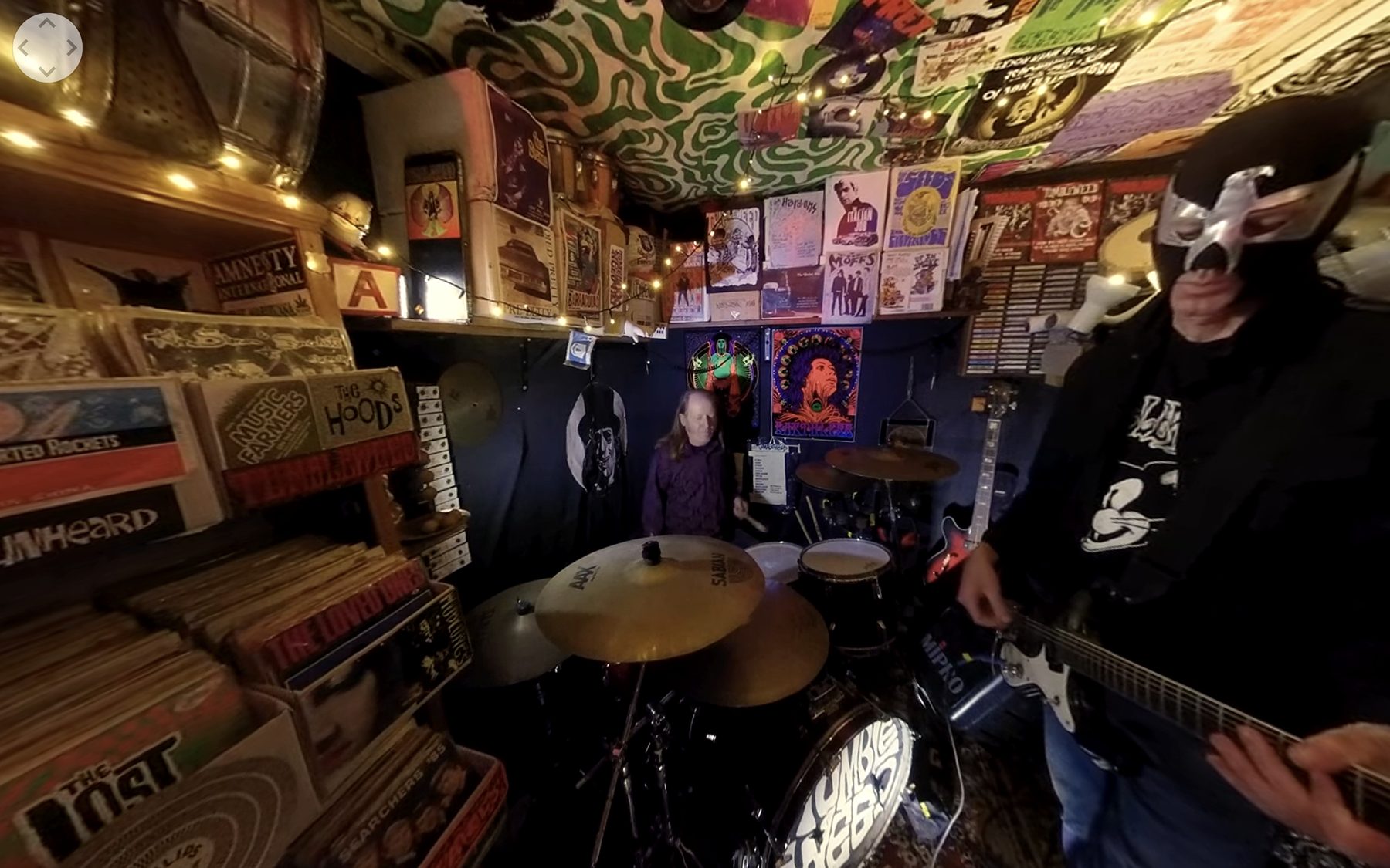 Wide view of the band's rehearsal room filled with gig posters and records